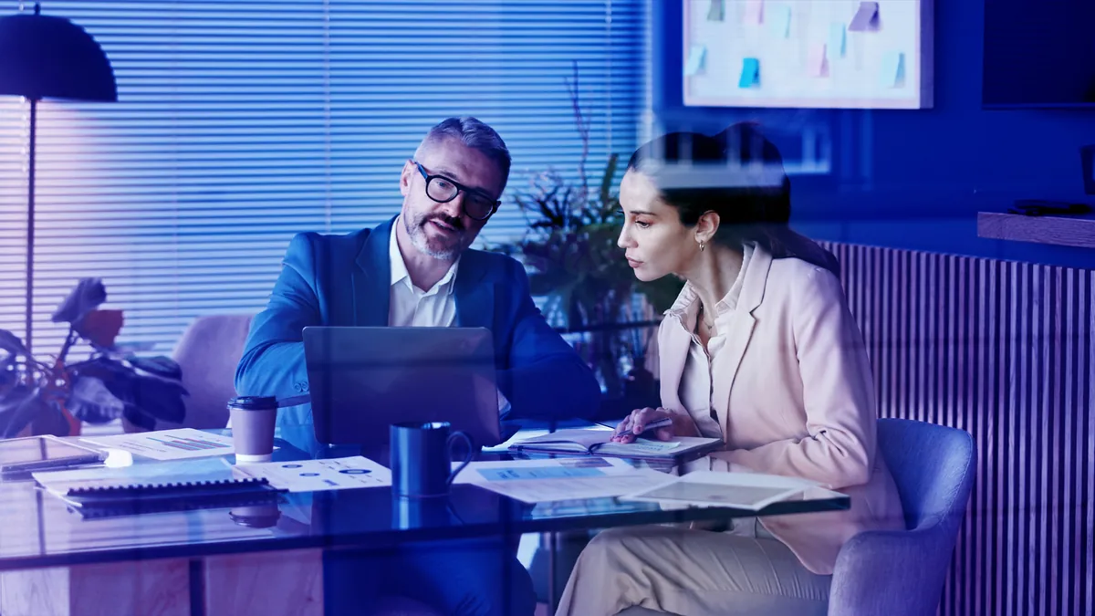 Deux collaborateurs étudient des chiffres de vente sur un ordinateur